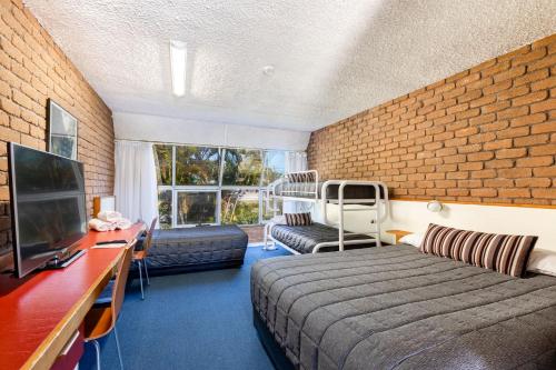 科夫斯港阿曲亚吉汽车旅馆的酒店客房,设有床铺和砖墙