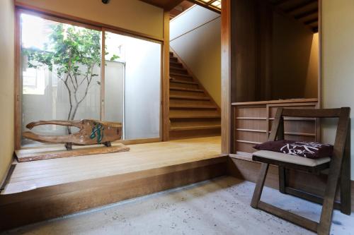 京都Konuka Yakushi Temple House的客房设有楼梯、椅子和窗户。