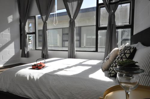 GrangeThe One @ Henley Beach的一间卧室设有一张床,窗户与窗户相连