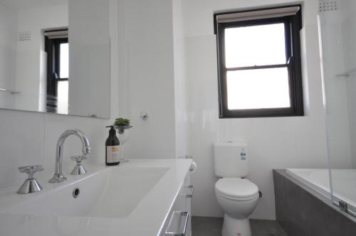 GrangeThe One @ Henley Beach的白色的浴室设有卫生间和窗户。