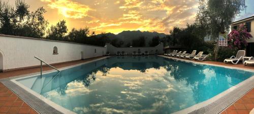 马尔切西内Residence Alesi的一个带椅子的游泳池,享有日落美景