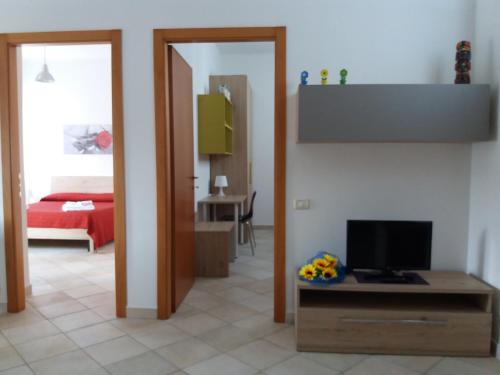 乌尔巴尼亚Appartamento Casteldurante的带电视的客厅和卧室