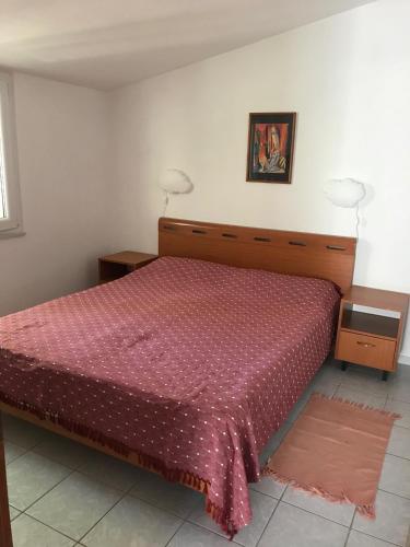 博罗维奇Apartmani Šehović的一间卧室配有一张红色床罩和2个床头柜的床
