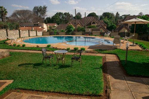内罗毕吉吉里兰花屋住宿加早餐旅馆的一个带桌椅的庭院和一个游泳池