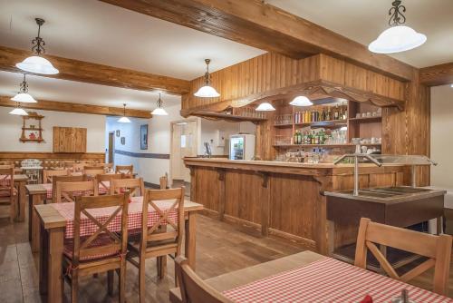 韦尔卡鲁穆尼卡塔特拉高尔夫山度假酒店的一间设有木墙和桌子的餐厅和一间酒吧