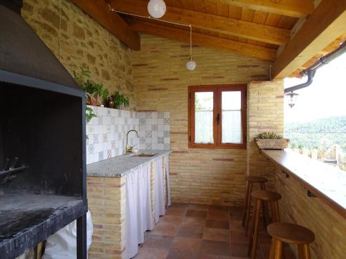 Morillo de MonclúsCasa L'Apargatero的厨房配有水槽和带凳子的台面