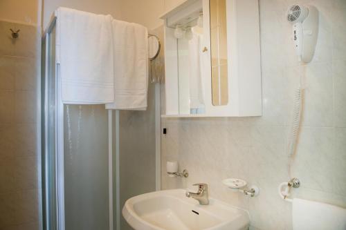 洛雷托Hotel Centrale di Paolo e Cinzia的白色的浴室设有水槽和淋浴。