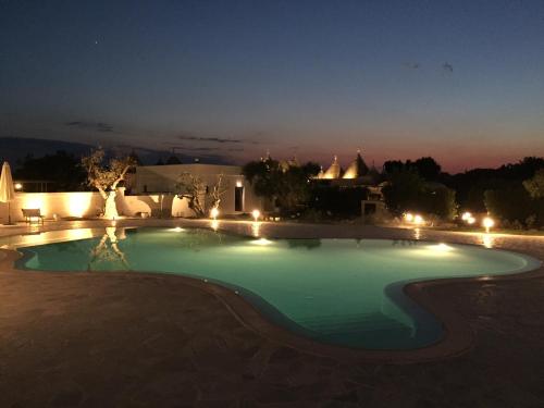 洛科罗通多Trulli IsAgo的夜间大型游泳池,灯光照亮