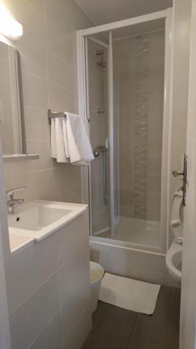 巴黎贝尔塔酒店的白色的浴室设有水槽和淋浴。