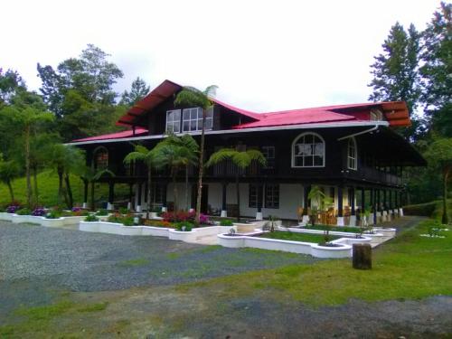 San Juan ChamelcoHotel en Finca Chijul, reserva natural privada的一间红色屋顶的黑色房子