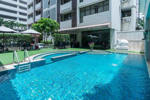 曼谷UHG阿索克素坤逸酒店的大楼前的大型蓝色游泳池