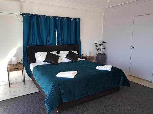 洛坎普顿洛克汉普顿Q汽车旅馆的一间卧室配有一张带蓝色毯子的大床