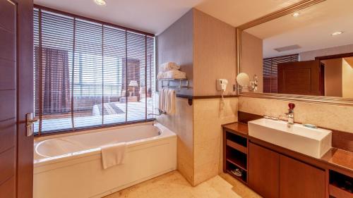 通州区北京太阳花酒店的带浴缸、水槽和窗户的浴室