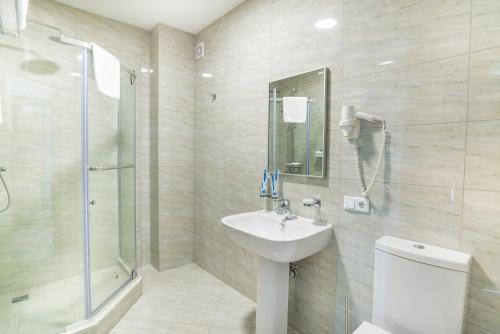 阿拉木图皇宫酒店的一间带水槽、淋浴和卫生间的浴室