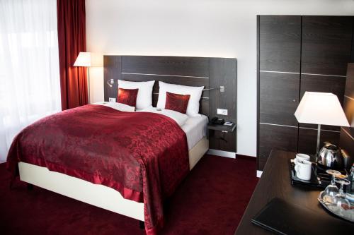 杜伊斯堡日恩盖特恩酒店的酒店客房设有一张大床和一张书桌。