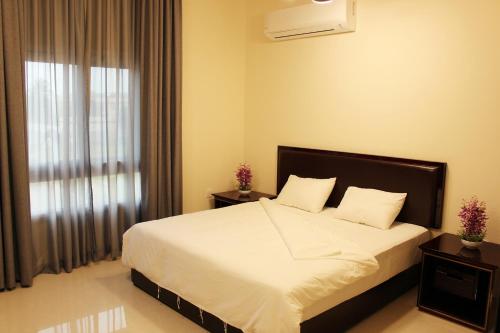 塞拉莱Al Noor Plaza的一间卧室配有一张带白色床单的床和一扇窗户。