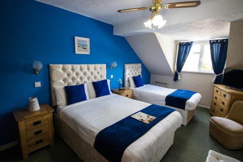 兰代洛白鹿旅馆的一间卧室设有两张带蓝色墙壁和天花板的床。