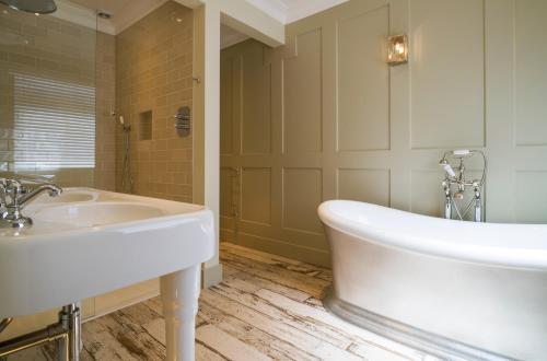 雷德鲁斯彭文顿公园酒店的浴室配有白色浴缸和水槽