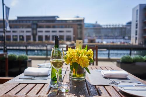 利物浦马尔马逊利物浦酒店的一张桌子,上面放着一瓶葡萄酒和鲜花