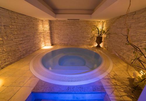 博萨迪法萨阿尼卡酒店的一个带砖墙的客房内的按摩浴缸