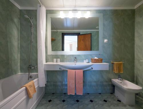 马希库多姆佩德罗马德拉酒店的一间带水槽、镜子和卫生间的浴室