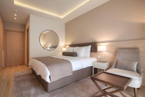布德瓦Hotel Villa Gracia的一间卧室配有一张床、一把椅子和镜子