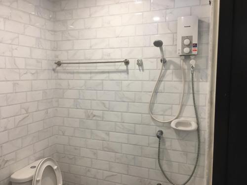 三帕兰Ben at Salaya的带淋浴和卫生间的白色瓷砖浴室