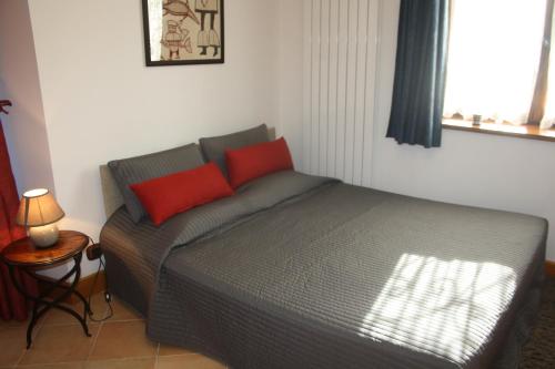 Vaulnaveys-le-HautAu pied des Alpes的卧室内的一张带两个红色枕头的床