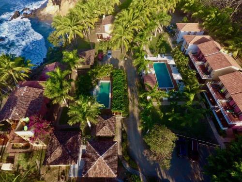 JobalHotel Punta Franca的享有棕榈树和海洋度假村的空中景致