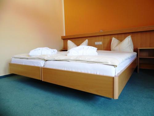 耶拿Hotel & Restaurant Zur Weintraube的一间卧室配有带白色床单和枕头的床。