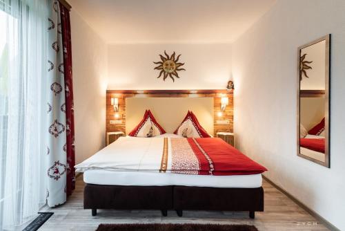巴德米滕多夫Appartementhaus Theresia的一间卧室配有一张带红色和白色棉被的床