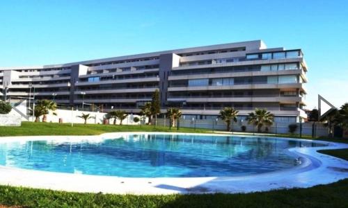 滨海罗克塔斯Apartamento Lujo, Primera linea playa, Garaje, Wifi, Piscina climatizada的大楼前的大型游泳池