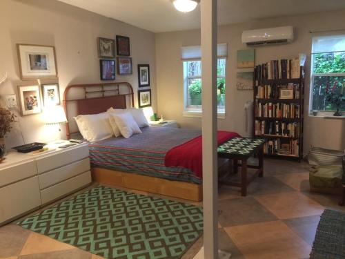 迈阿密The Wild Rose的一间卧室配有一张床、一张书桌和一个书架