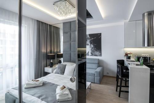克拉科夫Crystal Luxury Apartments Rakowicka 22H的一间带一张床和一张书桌的卧室和一间厨房