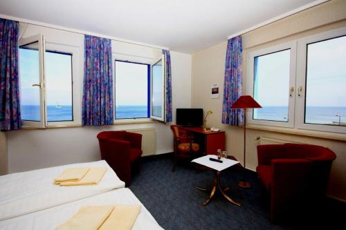 奥斯特巴特宁哈根尼恩哈格斯塔德酒店的酒店客房带两张床、椅子和窗户