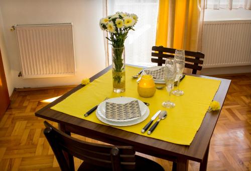 尼什Anthony的一张餐桌,上面有黄色的桌布和花瓶