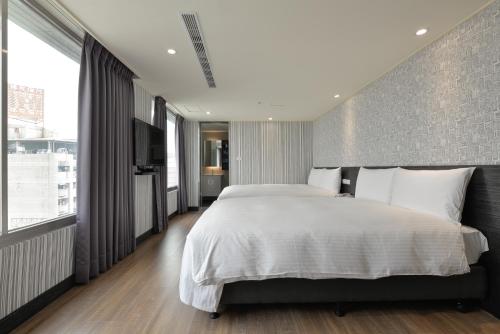 台中市香富大饭店的一间卧室设有一张大床和砖墙
