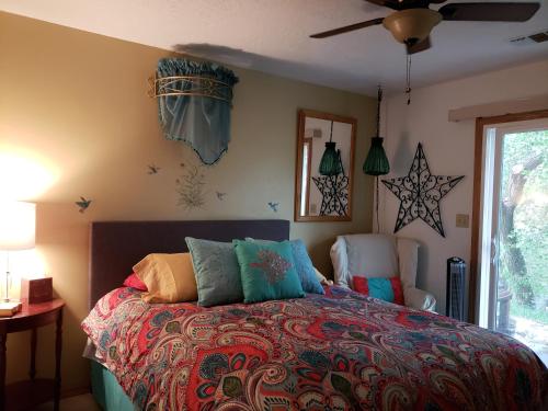 科尔特斯Grizzly Roadhouse Bed and Breakfast的一间卧室配有一张色彩缤纷的床和两把椅子