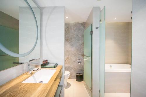 独鲁万XYZ酒店的浴室配有盥洗盆、卫生间和浴缸。