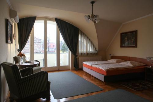 凯奇凯梅特Barokk Antik Guest Hause的一间卧室设有一张床和一个大窗户