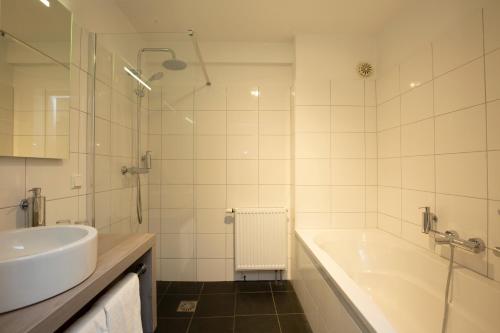 洛赫姆帕斯贝格弗莱彻餐厅-酒店的白色的浴室设有浴缸和水槽。