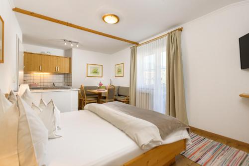 阿尔滕马克特蓬高瑞特公寓的一间带白色床的卧室和一间厨房