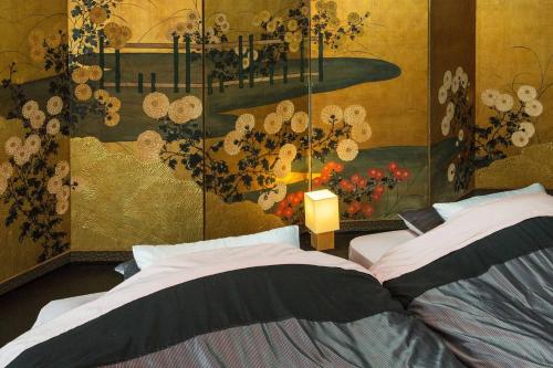 京都京都二条城近く京町屋120年の歴史に泊まる的一间卧室设有两张床,墙上挂着一幅画