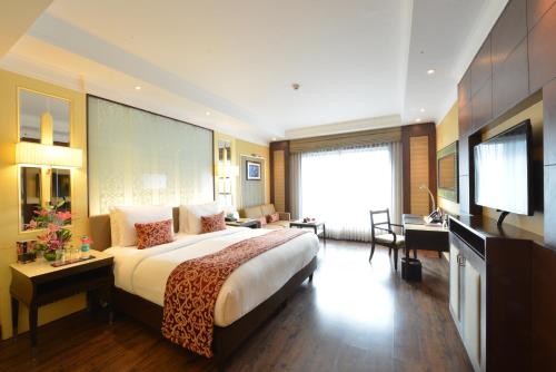 钦奈Ramada Plaza Chennai的酒店客房设有一张大床和一台电视。