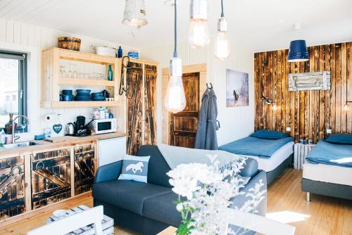 ÖlfusAkurgerði Guesthouse 4 - Country Life Style的一间带蓝色沙发的客厅和一间厨房