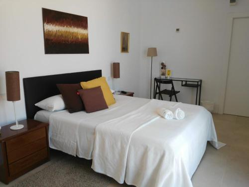 塞维利亚Casa Oliva 52的卧室配有带毛巾的大型白色床
