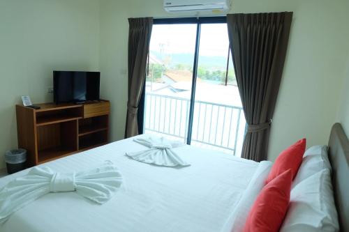 奈扬海滩DOS'S HOUSE的一间卧室设有一张床,阳台配有电视。