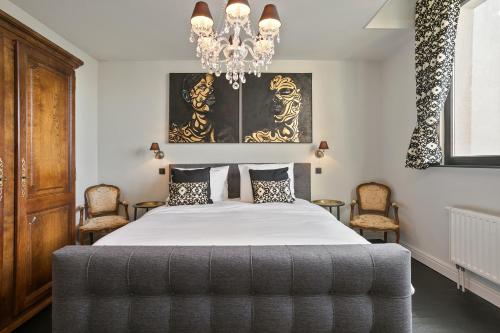 安特卫普Puur B&B的一间卧室配有一张带吊灯和椅子的床