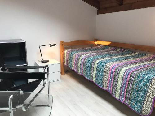 GambarognoCasa al Castagno的一间卧室配有一张带灯具的床和一台电视