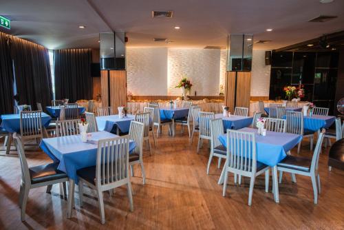 坤敬曼特拉瓦雷酒店的用餐室配有蓝色桌子和白色椅子